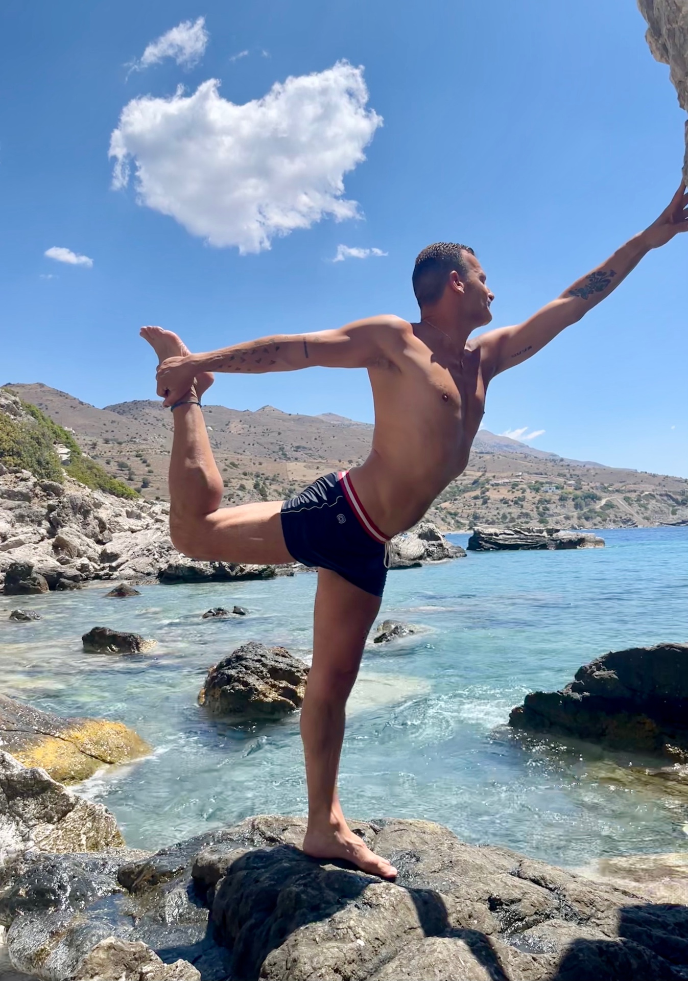 Meïr Bar-Maymon in Natarajasana on a rock by the sea